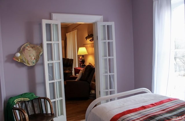 bedroom with multiple windows, french doors, and wood-type flooring