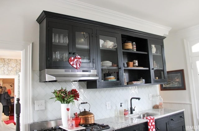 bar with backsplash, light stone counters, ornamental molding, sink, and range hood