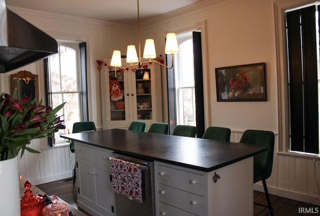 kitchen with white cabinets, pendant lighting, a kitchen bar, and dark wood-type flooring