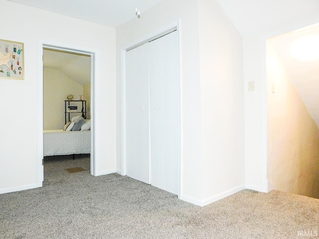 hall featuring carpet floors and vaulted ceiling