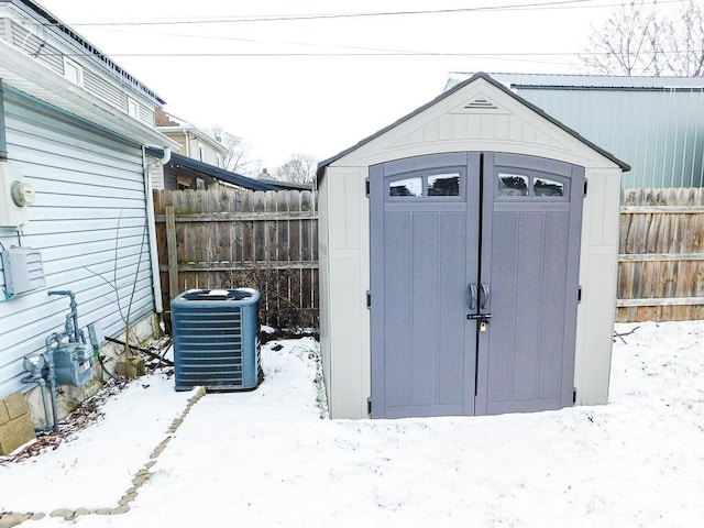 snow covered structure featuring central AC unit