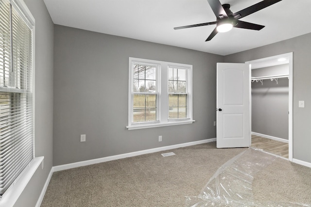 unfurnished bedroom featuring ceiling fan, a closet, and light colored carpet