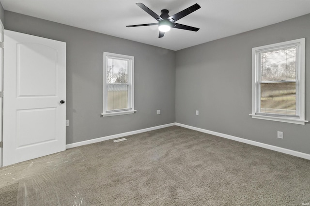 unfurnished room with carpet floors, ceiling fan, and a healthy amount of sunlight