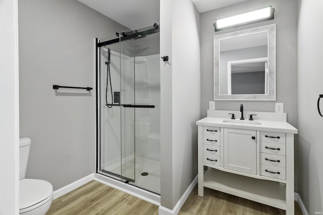 bathroom featuring vanity, hardwood / wood-style flooring, toilet, and walk in shower