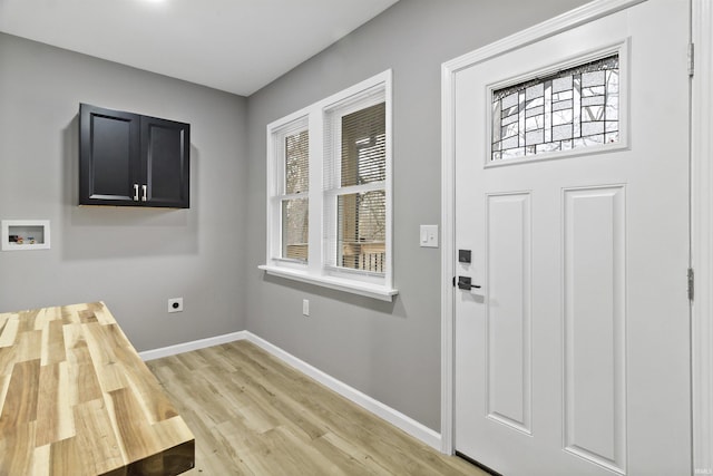 interior space with washer hookup, electric dryer hookup, cabinets, and light hardwood / wood-style flooring