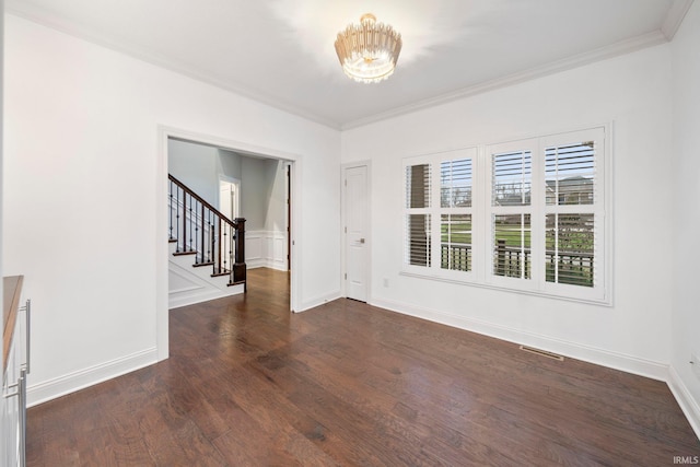 unfurnished room featuring dark hardwood / wood-style flooring, crown molding, and a chandelier