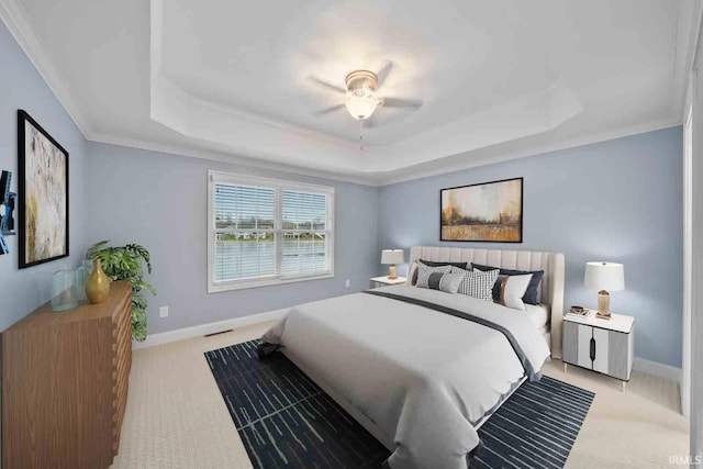 bedroom featuring a tray ceiling, ceiling fan, and ornamental molding