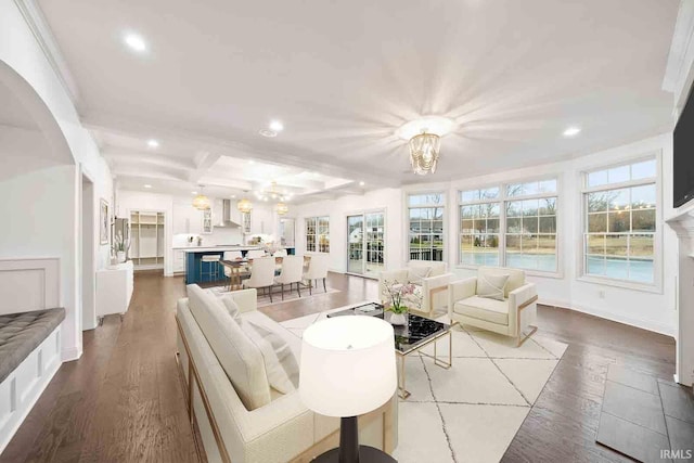 living room with beam ceiling, coffered ceiling, a notable chandelier, and light wood-type flooring