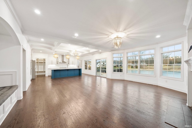 unfurnished living room with beamed ceiling, a chandelier, crown molding, and coffered ceiling