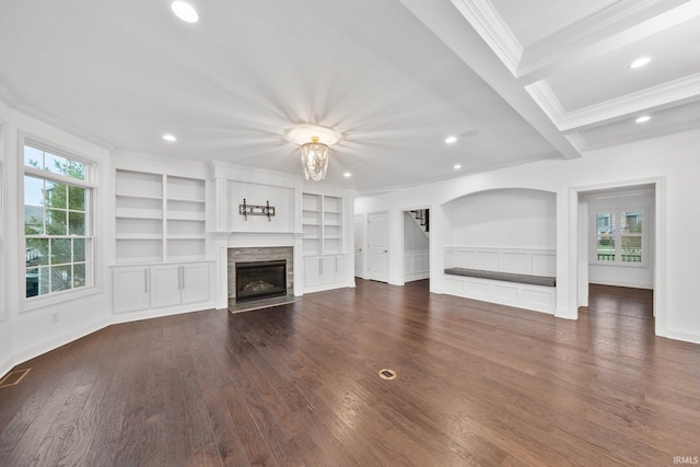 unfurnished living room with built in shelves, crown molding, a fireplace, and beamed ceiling