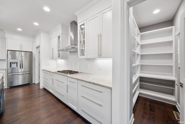 kitchen with wall chimney exhaust hood, stainless steel appliances, tasteful backsplash, dark hardwood / wood-style floors, and white cabinets