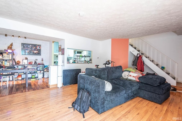 living room with wood-type flooring and a textured ceiling