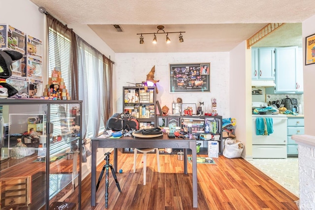 dining space with a textured ceiling and hardwood / wood-style flooring