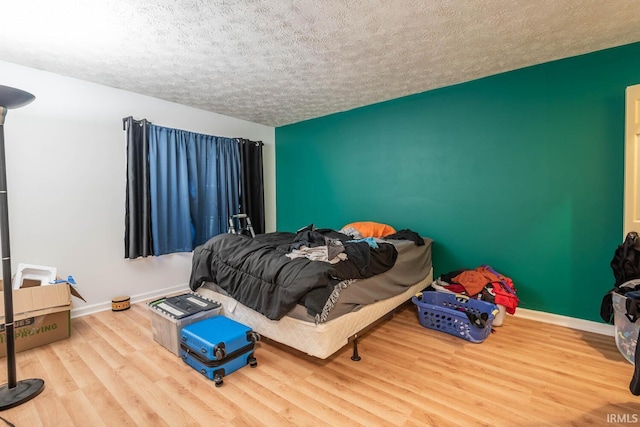 bedroom featuring hardwood / wood-style floors and a textured ceiling