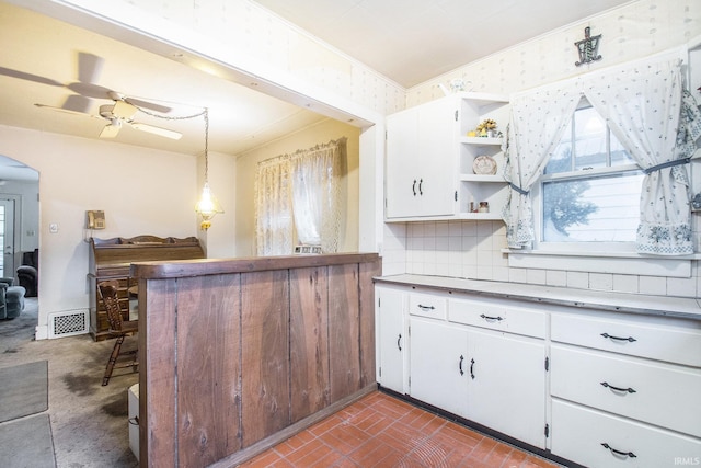 kitchen featuring decorative backsplash, white cabinetry, ceiling fan, and hanging light fixtures