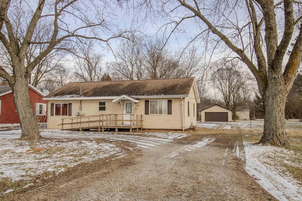 view of front facade featuring an outbuilding, a deck, and a garage