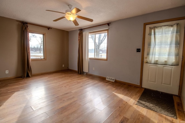 foyer with ceiling fan, a textured ceiling, and a wealth of natural light