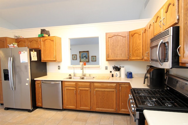 kitchen featuring light tile patterned floors, stainless steel appliances, lofted ceiling, and sink