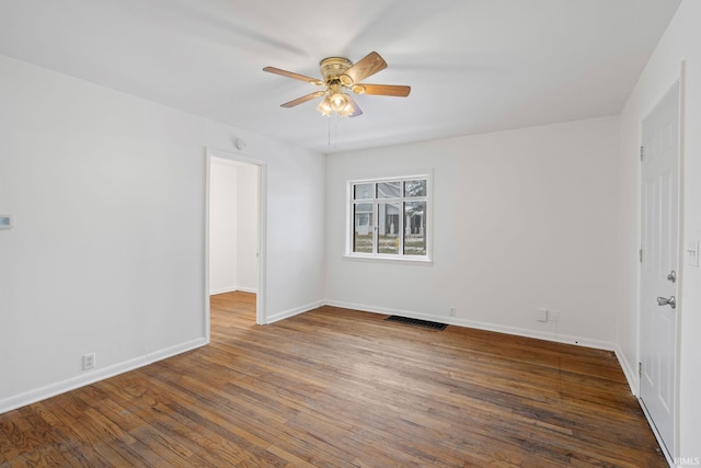 empty room with ceiling fan and dark hardwood / wood-style flooring