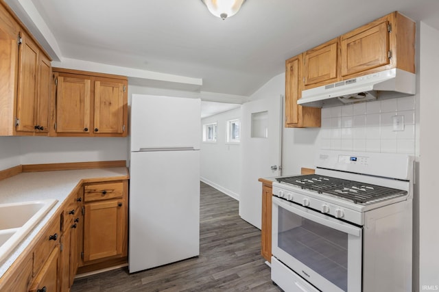 kitchen featuring decorative backsplash, white appliances, dark hardwood / wood-style floors, and sink