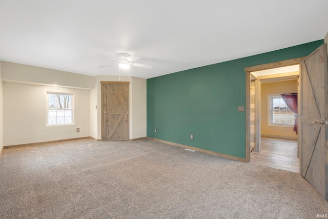 unfurnished bedroom with ceiling fan and light colored carpet