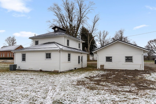 snow covered back of property featuring central air condition unit