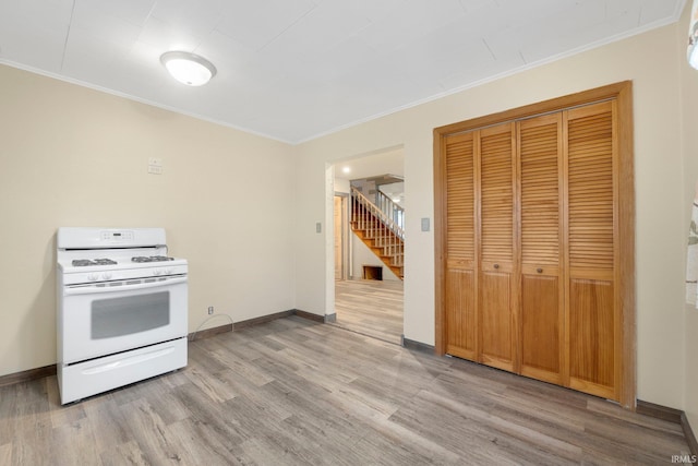 kitchen with light wood-type flooring, white range with gas stovetop, and crown molding