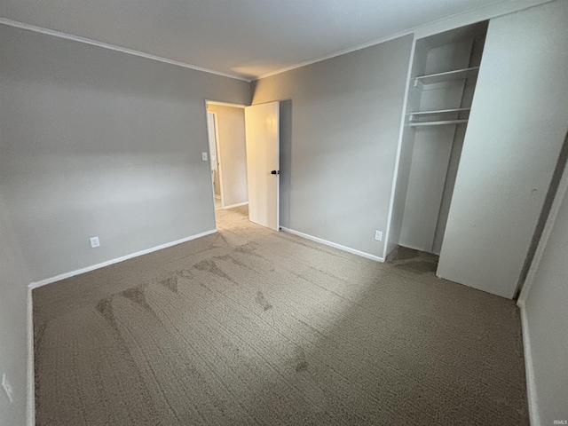 unfurnished bedroom with carpet flooring, crown molding, and a closet