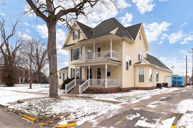 view of front of home featuring covered porch, central air condition unit, and a balcony