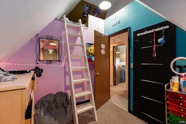 bedroom with light colored carpet and lofted ceiling