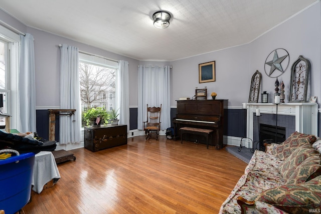 living room with wood-type flooring and a tiled fireplace