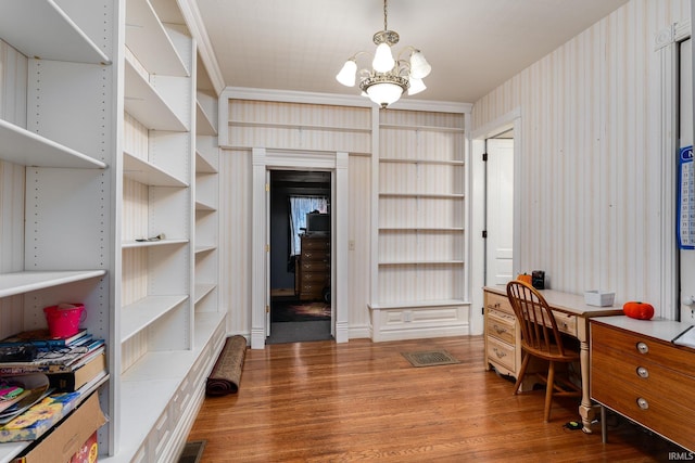 home office with hardwood / wood-style floors, an inviting chandelier, and crown molding