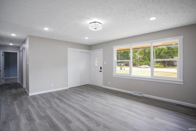 spare room with a textured ceiling and hardwood / wood-style flooring