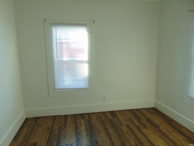 unfurnished room with dark hardwood / wood-style flooring