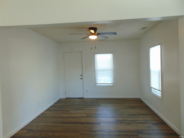 empty room with ceiling fan and dark hardwood / wood-style flooring