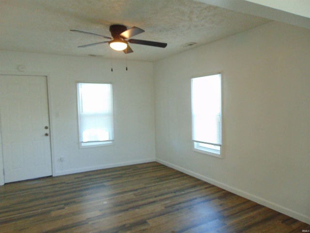 unfurnished room with dark hardwood / wood-style flooring, plenty of natural light, and ceiling fan