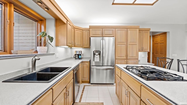 kitchen featuring light brown cabinetry, sink, light tile patterned flooring, and stainless steel appliances