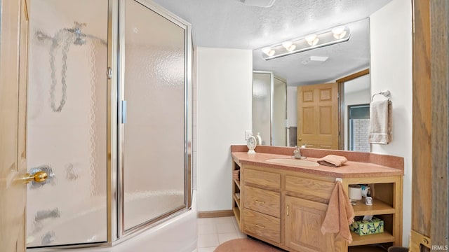 bathroom with tile patterned flooring, vanity, a textured ceiling, and bath / shower combo with glass door