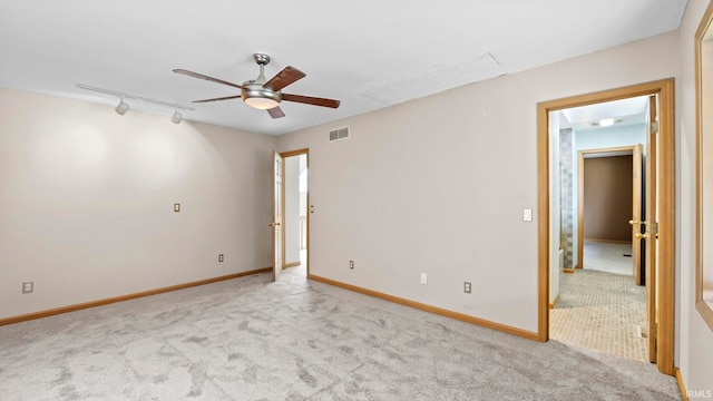 unfurnished room with rail lighting, ceiling fan, and light carpet