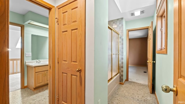 hall featuring light tile patterned floors and sink