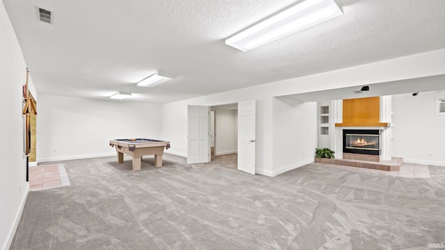 playroom with a textured ceiling, light colored carpet, and pool table