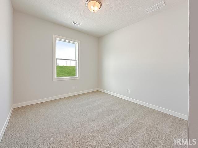 unfurnished room featuring light carpet and a textured ceiling