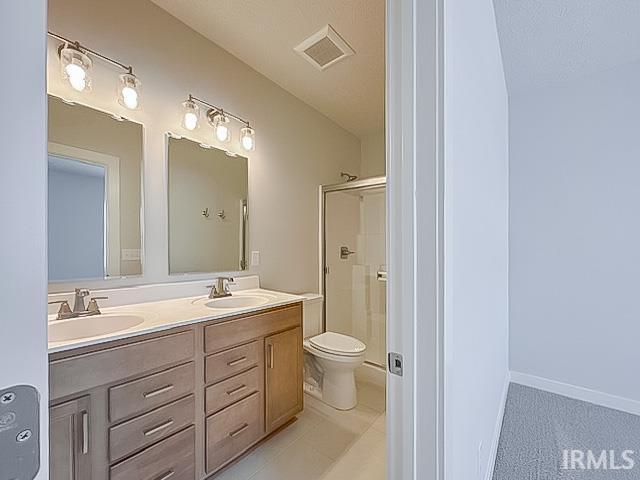 bathroom featuring vanity, toilet, and an enclosed shower