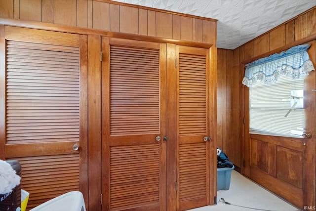 interior details featuring a textured ceiling and wooden walls