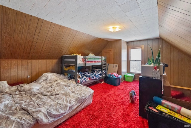 carpeted bedroom with wooden walls and lofted ceiling