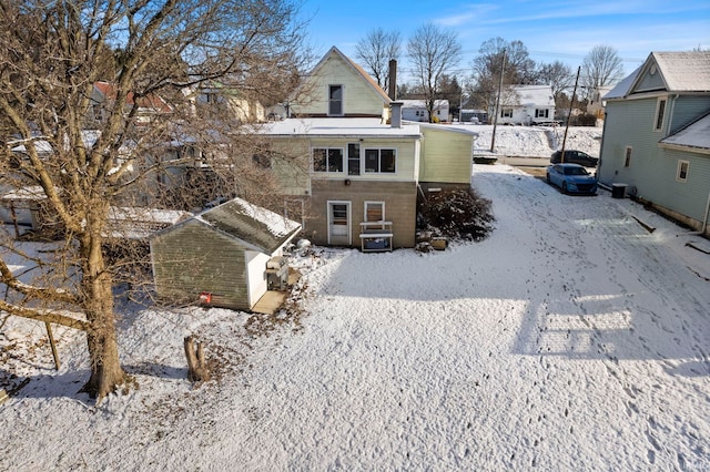 view of snow covered rear of property