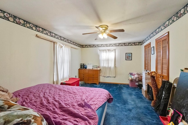 carpeted bedroom with ceiling fan and multiple closets