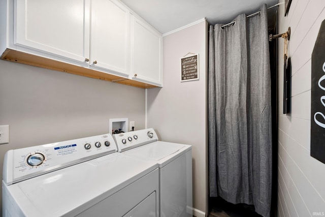 clothes washing area with washer and clothes dryer and cabinets