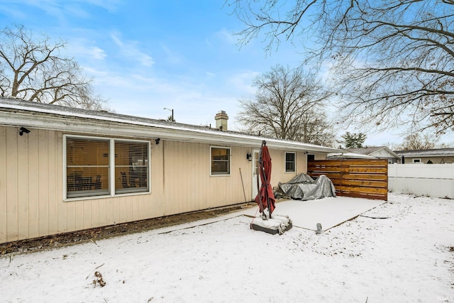 view of snow covered rear of property