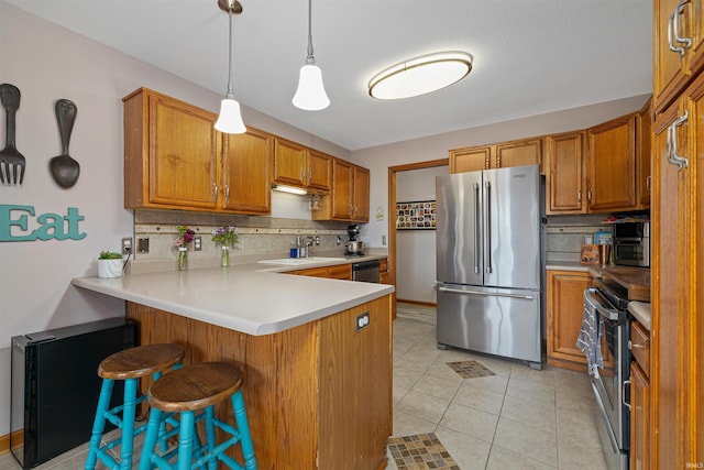 kitchen featuring stainless steel appliances, kitchen peninsula, pendant lighting, a breakfast bar, and light tile patterned floors